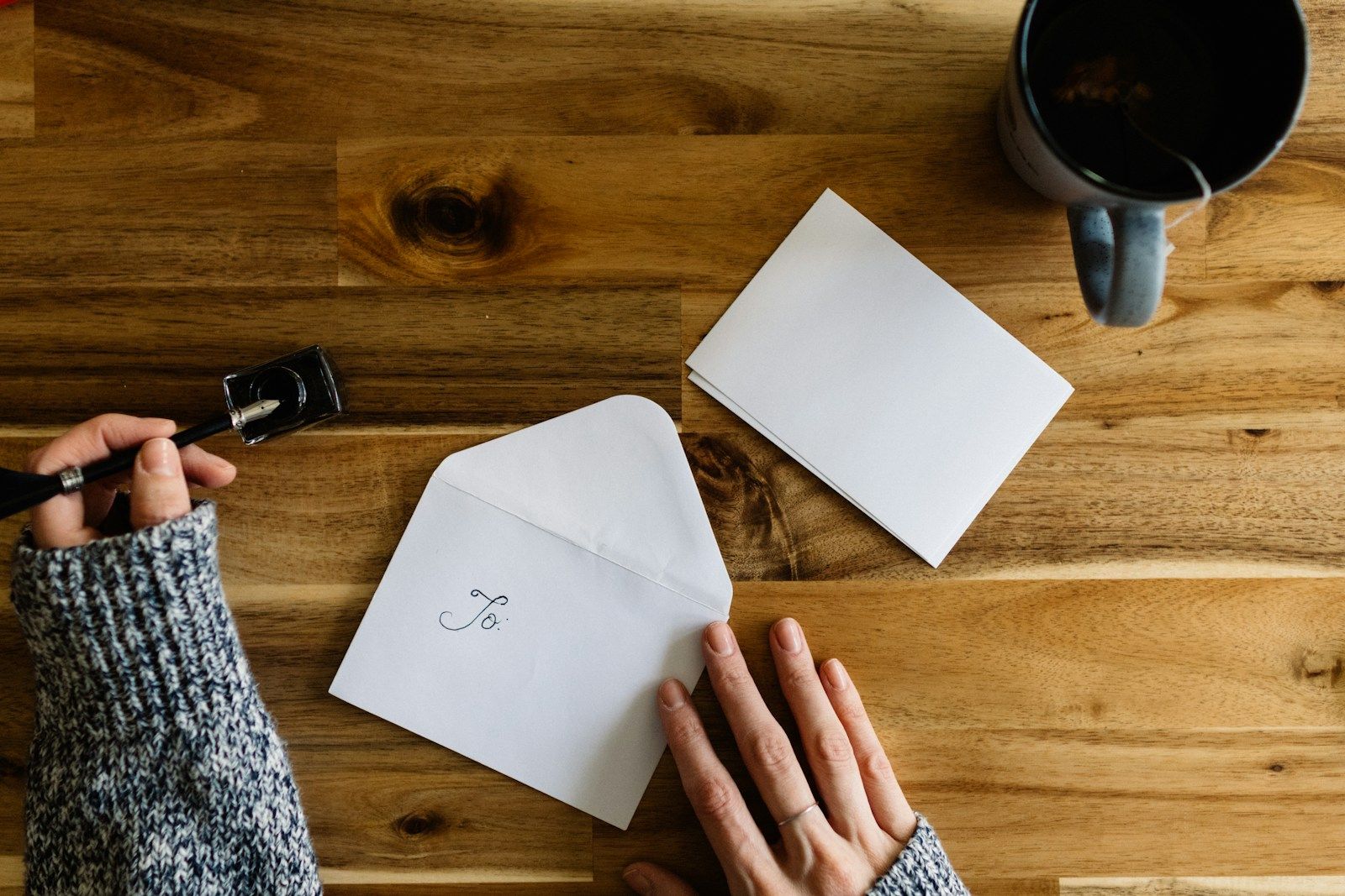 An envelope and a cup of coffee on a wooden table