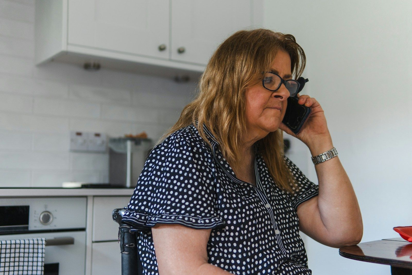 A woman on the phone in her kitchen